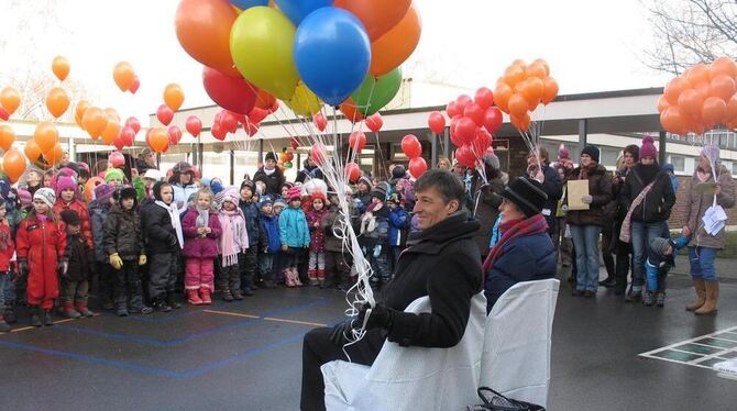 Bürgermeister Klaus Bender, seine Frau Angelika und 260 Kinder mit ebenso vielen Luftballons auf dem Pausenhof der Riedericher G