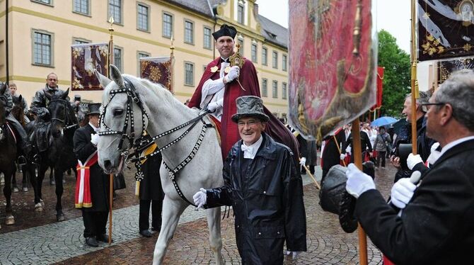 Dekan Ekkehard Schmid, der sogenannte Blutreiter, hält in Weingarten beim traditionellen Blutritt auf einem Schimmel die Heilig-