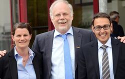 Annette Bauer und Sebastian Honscheck, die sich um den Bürgermeisterposten in Grafenberg bewerben, väterlich umarmt vom Amtsinha