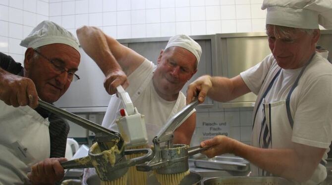 Mit Druck in den Topf: Helmut Knoblich, Jürgen Hirning und Bruno Müller (von links) beim Spätzlemachen. GEA-FOTO: HAILFINGER