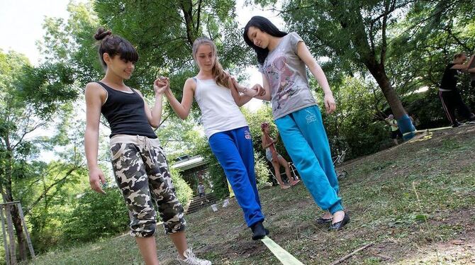 Zu dritt geht es besser: Balancieren auf der Slackline schult das Gleichgewicht. FOTO: ZAWADIL