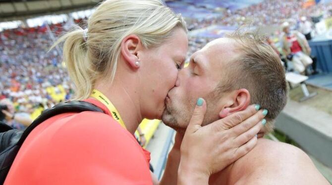 Diskus-Weltmeister Robert Harting knutscht nach seinem Sieg mit Freundin Julia Fischer. Foto: Michael Kappeler