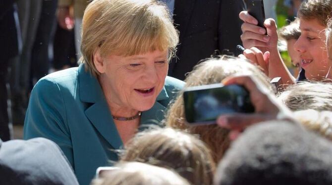 BundeAngela Merkel umringt von Schülern des Heinrich Schliemann Gymnasium in Berlin. Foto: Tim Brakemeier