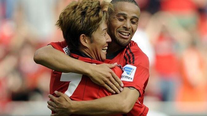 Heung-Min Son (l) und Sidney Sam jubeln über ein Tor für Bayer Leverkusen. Foto: Marius Becker