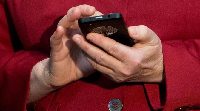 Bundeskanzlerin Angela Merkel mit einem abhörsicheren Blackberry am Stand von Secusmart auf der Computermesse CeBIT in Hannov