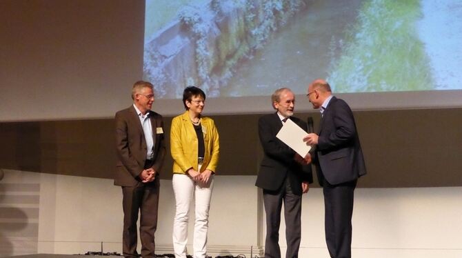 Minister Winfried Hermann (rechts) überreicht Bürgermeister Rudolf Heß die Urkunde für das Pfullinger Projekt, links daneben Wal