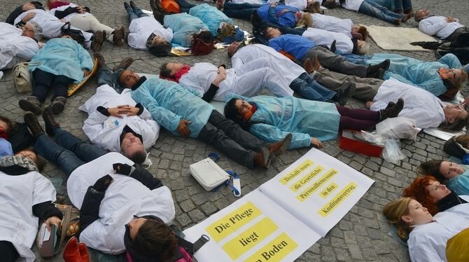 Auf dem kalten Boden: Liegender Protest von Tübinger Pflegekräften gegen Personalnotstand in den Kliniken.  FOTO: NIETHAMMER