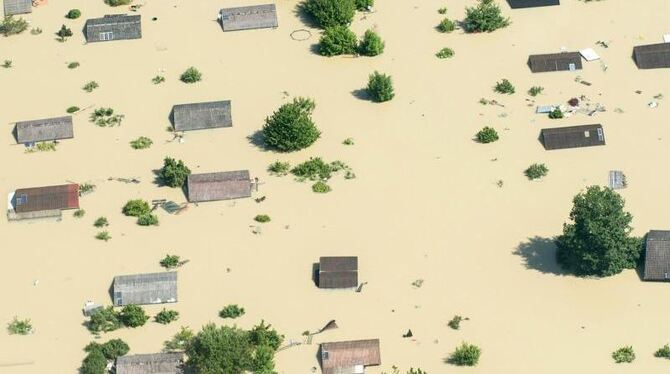 Dächer ragen am 5. Juni 2013 nahe Deggendorf nach einem Dammbruch aus dem Hochwasser der Donau. Foto: Armin Weigel/Archiv