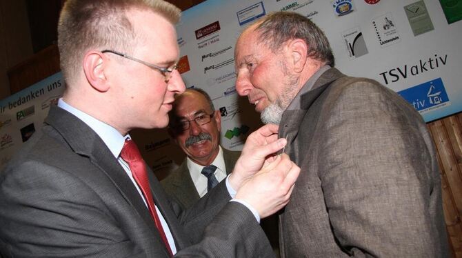 Mario Storz zeichnet Hubert Binder (rechts) mit  der  Ehrennadel  aus.  Im  Hintergrund Ulrich Kaufmann. FOTO: KOZJEK