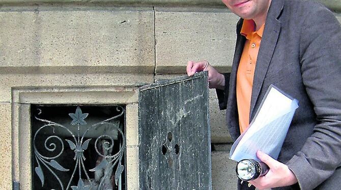 Martin Fink vor einem Kellerfenster der Laiblinvilla. Das Laub-Ornament im Gitter verweist auf das Wappen der Laiblins. FOTO: KA