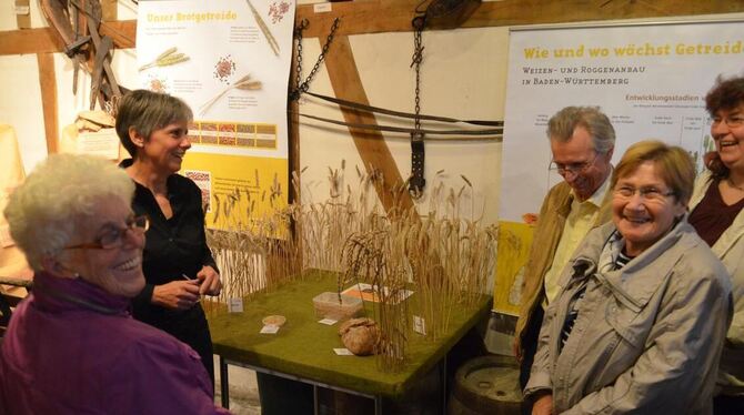 Karin Kuhn-Schmidgall (Zweite von links) zeigt den Ausstellungsbesuchern, wie viele Körner im Brot stecken. GEA-FOTO: SAUTTER