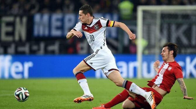 Dynamisch: Deutschlands Julian Draxler ist schneller als Polens Ludovic Obraniak (rechts).  FOTO: DPA