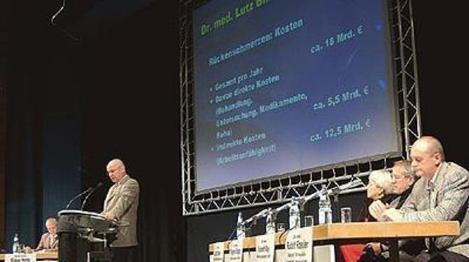 Konzentrierte Zuhörer auch auf dem Podium: Dr. Lutz Binder, Oberarzt der Klinik-Schmerzambulanz, am Redepult. FOTOS: NIETHAMMER