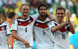 Erschöpft, aber glücklich bejubeln Hoewedes, Khedira und Lahm mit den Fans den Halbfinaleinzug. Foto: Oliver Weiken