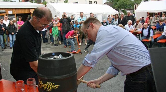 Engstingens  Bürgermeister  Mario  Storz  und Feuerwehrkommandant Anton Hummel, links, beim Fassanstich zum Auftakt der Schlossh