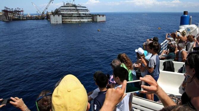 Touristenattraktion: Schaulustige warten auf den Abtransport der »Costa Concordia«. Foto: Alessandro Di Meo