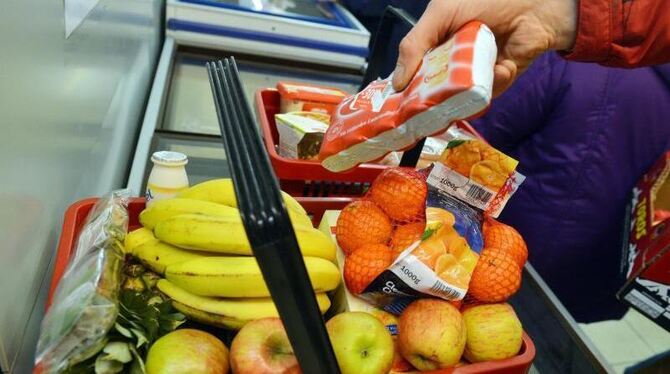 Ein Kunde füllt seinen Einkaufskorb mit Obst und Gemüse. Foto: Uli Deck/Symbol