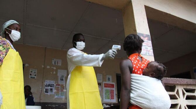 Eine liberianische Krankenschwester überprüft die Temperatur einer Frau. Foto: Ahmed Jallanzo