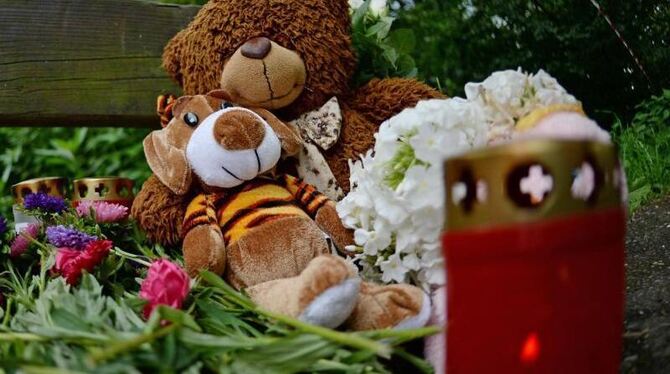 Kuscheltiere, Grablichter und Blumen liegen in Freiburg am Fundort des getöten achtjährigen Armani. Foto: Patrick Seeger/Arch