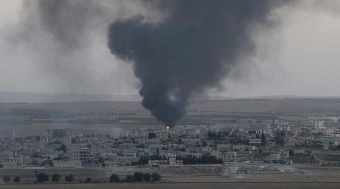 Türkische Panzer vor der Kulisse des umkämpften Kobane. Foto: Tolga Bozoglu