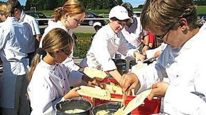 Während die 220 Miniköche schabten, schöpften engagierte Mütter und Väter die fertigen Spätzle in große Eimer. GEA-FOTO: PS