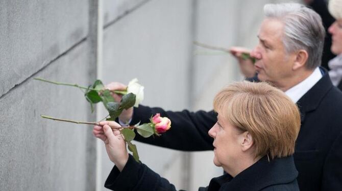 Bundeskanzlerin Angela Merkel und Berlins Regierender Bürgermeister Klaus Wowereit stecken während der Gedenkveranstaltung Ro