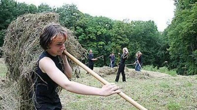 Beim Heuen: Schülerinnen und Schüler der Pfullinger Schloss-Schule auf der Trollblumenwiese. FOTO: REISNER