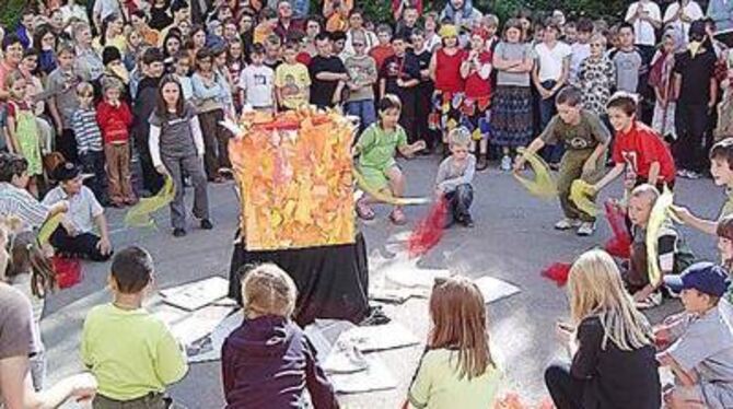 Gespannt verfolgten die Kinder auf dem Hof der Brögerschule, wie die kleine Hexe symbolisch Hexenbücher verbrannte. FOTO: MERKLE