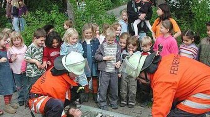 Spannung in den Kindergesichtern, als die Feuerwehr bei der Übung im Kindergarten einen &raquo;Verletzten&laquo; barg.  GEA-FOTO