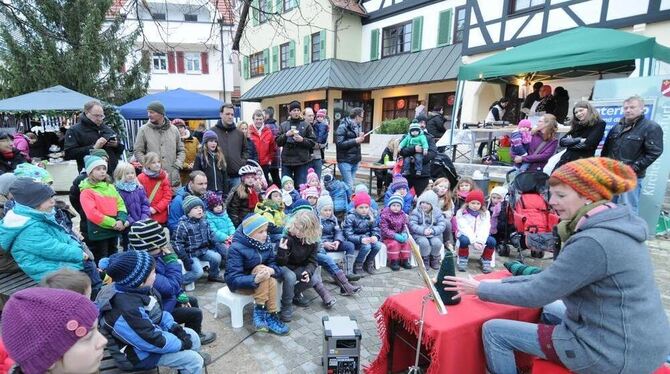 Eine Geschichtenerzählerin erfreut Kinder auf dem Kirchentellinsfurter Weihnachtsmarkt.