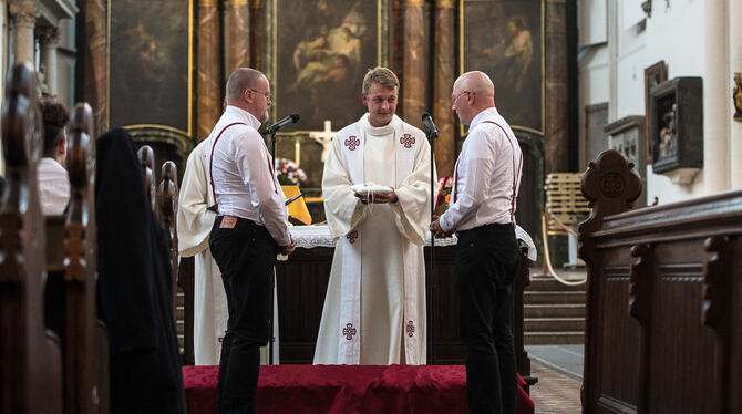 Dieses homosexuelle Paar tauscht vor einem Pfarrer in Berlin in einem feierlichen Traugottesdienst die Ringe. Die württembergisc