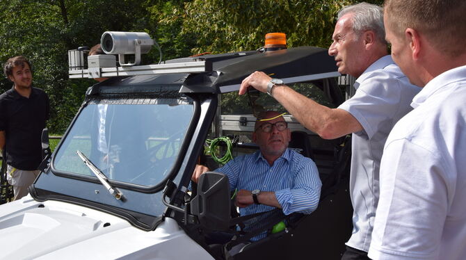 Verkehrsminister Winne Hermann am Steuer des Messfahrzeugs. Der Ortsvorsteher von Bebenhausen, Hansjörg Kurz, erklärt ihm, wo er