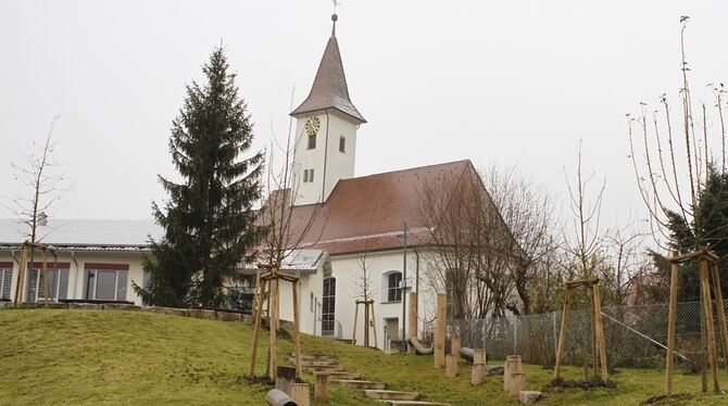 Hinten Kirche und Gemeindehaus, vorne Weg und Spielbereich, die zur Bushaltestelle führen. Was auf dem Foto nicht zu sehen ist: