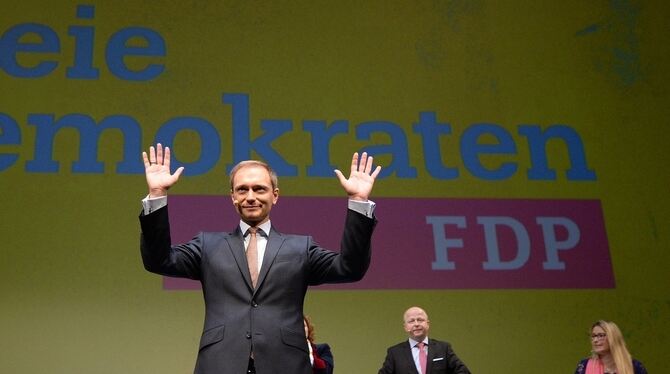 Christian Lindner (M), der Vorsitzende der FDP, winkt in Stuttgart im Opernhaus beim traditionellen Dreikönigstreffen der Partei