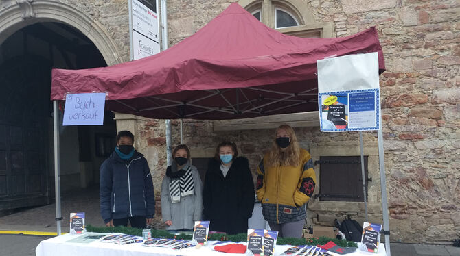 Schüler des Johannes-Kepler-Gymnasiums verkaufen ihr Buch auf dem Marktplatz in Reutlingen.  FOTO: PRIVAT