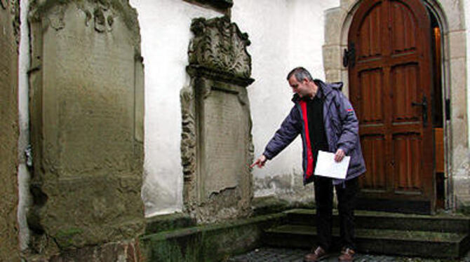 Stark beschädigt: Kirchenpfleger Eugen Siegel vor den Epitaphien der Martinskirche. GEA-FOTO: FÜS