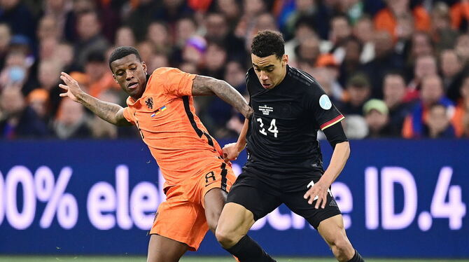 Nur schwer vom Ball zu trennen: Jamal Musiala (rechts), hier im Duell mit Georginio Wijnaldum.  FOTO: GROOTHUIS/WITTERS