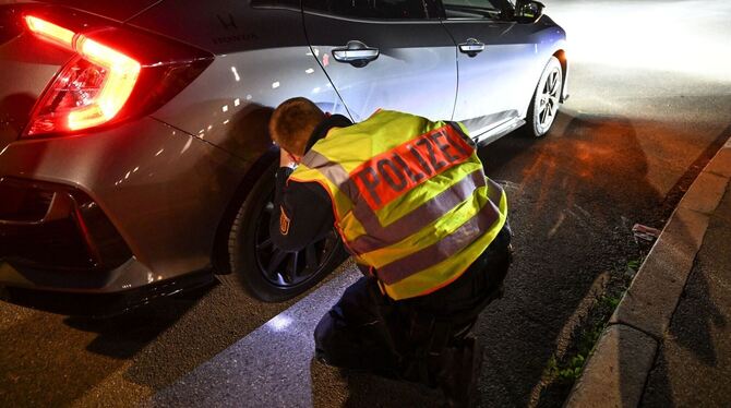 Ein Polizist kontrolliert ein Auto