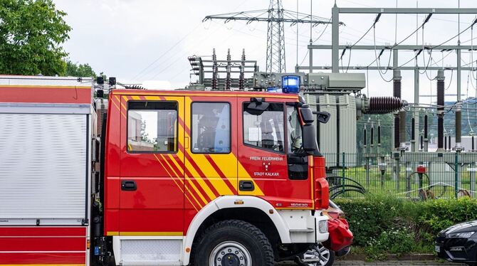 Ein Einsatzfahrzeug der Feuerwehr steht vor einem Umspannwerk.