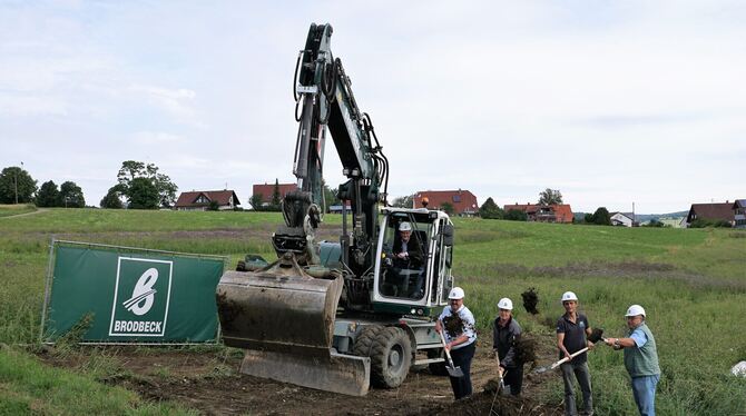 Engstingens  Bürgermeister Mario Storz (auf dem Bagger) mit Vertretern des Gemeinderats, der Baufirma und des Architekturbüros b