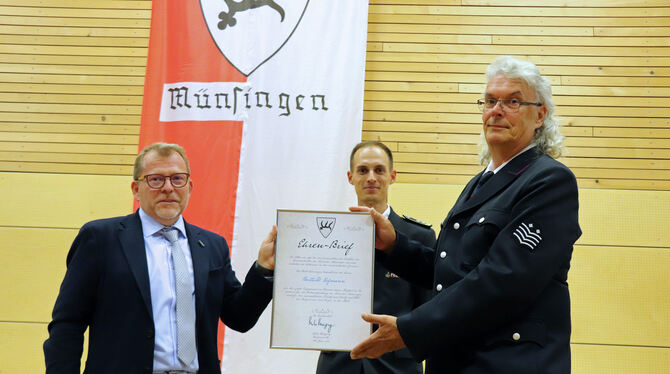 Bürgermeister Mike Münzing (links) überreicht Berthold Hofmann (rechts) den Ehrenbrief der Stadt Münsingen. In der Mitte Christo