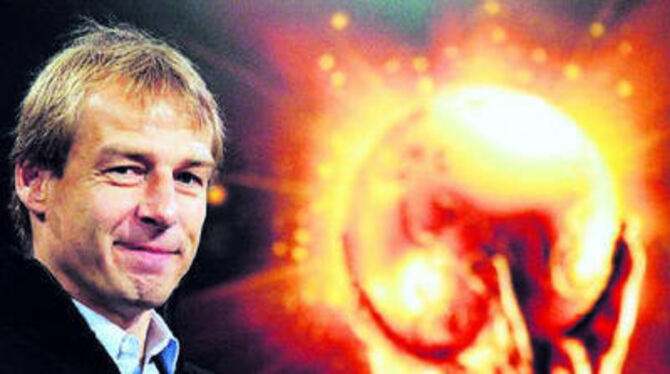 Ein Mann und sein Ziel: Bundestrainer Jürgen Klinsmann und der Weltpokal bei der WM-Auslosung in Leipzig.
FOTO: DPA