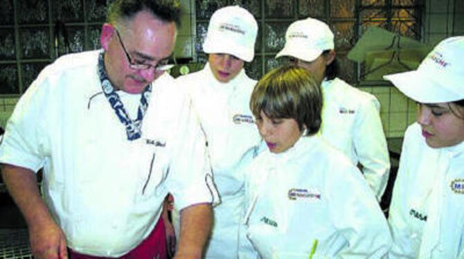 Wenn Walter Steeb Forelle filetiert, sieht's kinderleicht aus. Die Miniköche staunen ob der Fertigkeit des Küchenmeisters.
GEA-FOTO: US