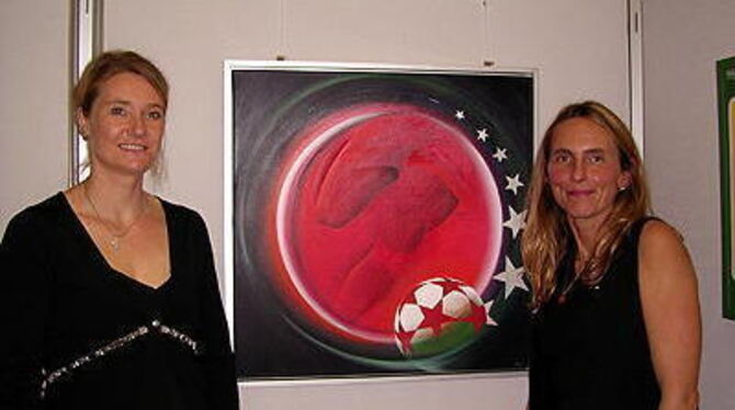 Gaby Staudinger (links) und Karin Fesseler zeigen Sportbilder in der Metzinger Kreissparkasse.
FOTO: FETZER