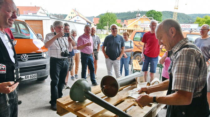 Flaschner Alfred Heinz (rechts) öffnete die Zeitkapsel der Turmzier. Pfarrer Matthias Wagner hält das Ereignis fotografisch fest