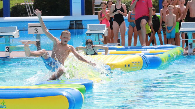 Hurra, es ist Freibadfest: Die Kids wurden mit vielen Spielen unterhalten wie hier beim Rennen übers Wasser.  FOTOS: REISNER