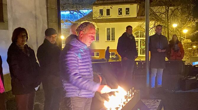 Gemeinderat Dietrich Rebstock entzündet eine der acht Flammen.  FOTO: FÖRDER