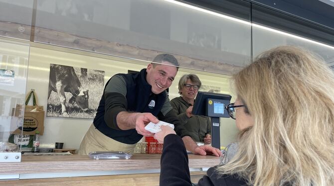 Nico Maucher verkauft einer Kundin aus seinem Transporter heraus Käse. Jeden Freitag fährt er vom Allgäu auf den Pfullinger Woch