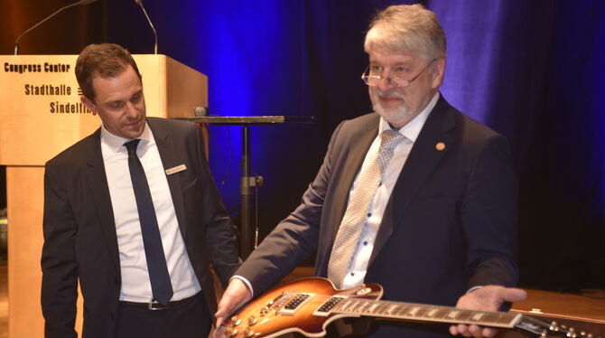 Wolfgang Klotz (rechts) und sein Nachfolger Jörg Niethammer: Zum Abschied gab's von der Bank eine neue Gitarre. FOTO: REICHERT