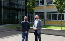 Mischa Blinzinger (links) und Silvan Purschwitz stehen vor dem Neu- und Altbau der Theodor-Heuss-Schule. Sie freuen sich auf die